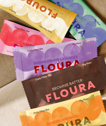 Assorted flavors of FLOURA fiber bars on a textured surface - hide-from-pdp