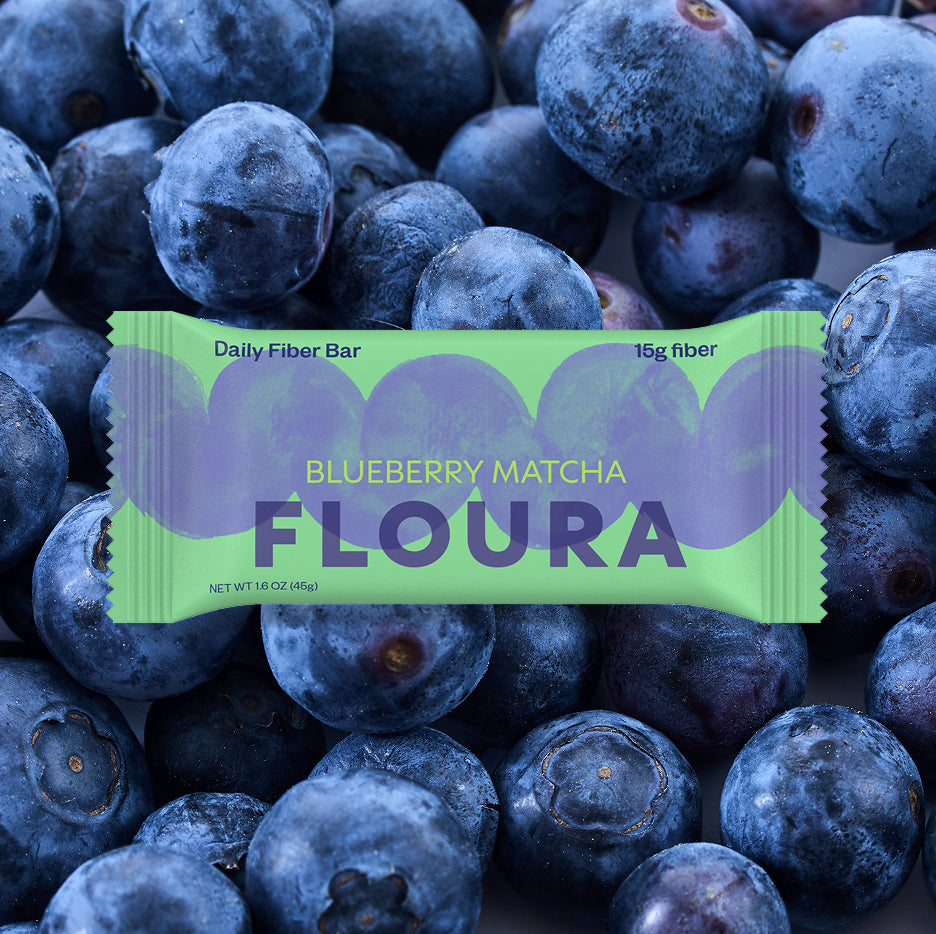 Floura Blueberry Matcha fiber bar on a background of blueberries hide-from-pdp
