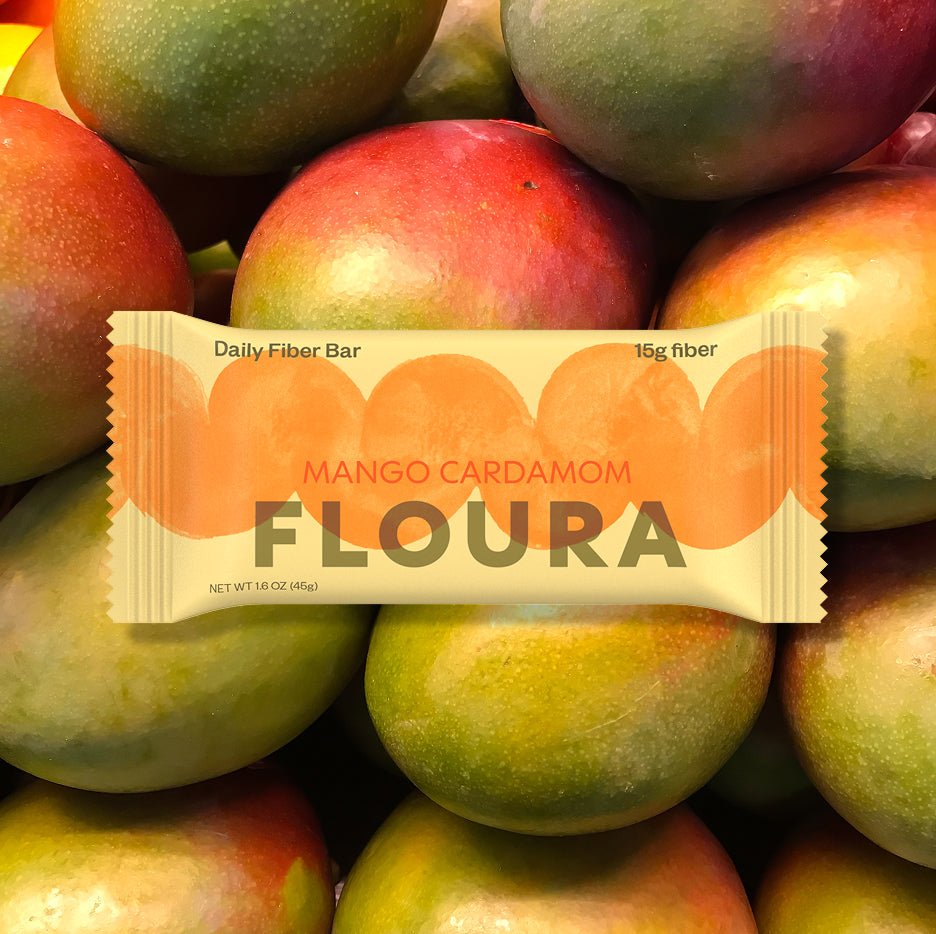 Floura Mango Cardamom fiber bar on a background of mangoes hide-from-pdp